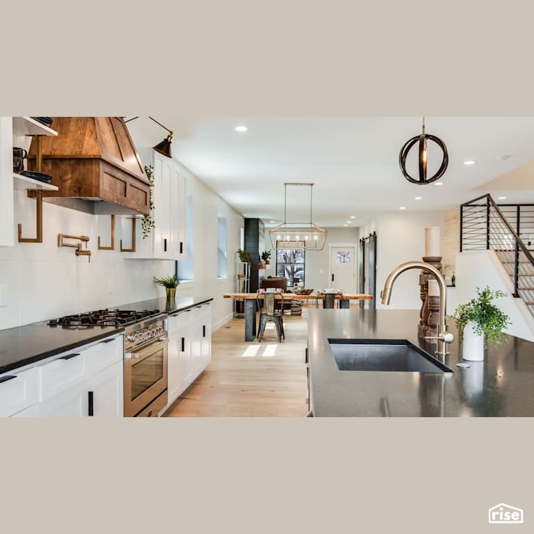 Open concept kitchen with wood grain range hood with Low-Flow Kitchen Faucet by Revolve Design Build
