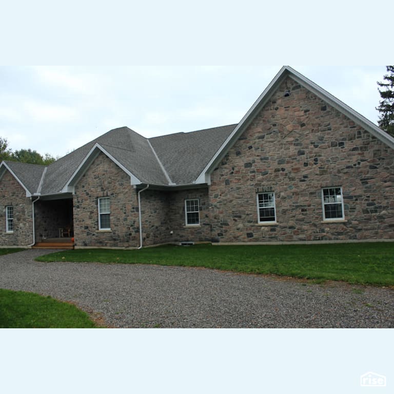 Stone home with gravel driveway with Stone Siding by Masonal Stone Inc