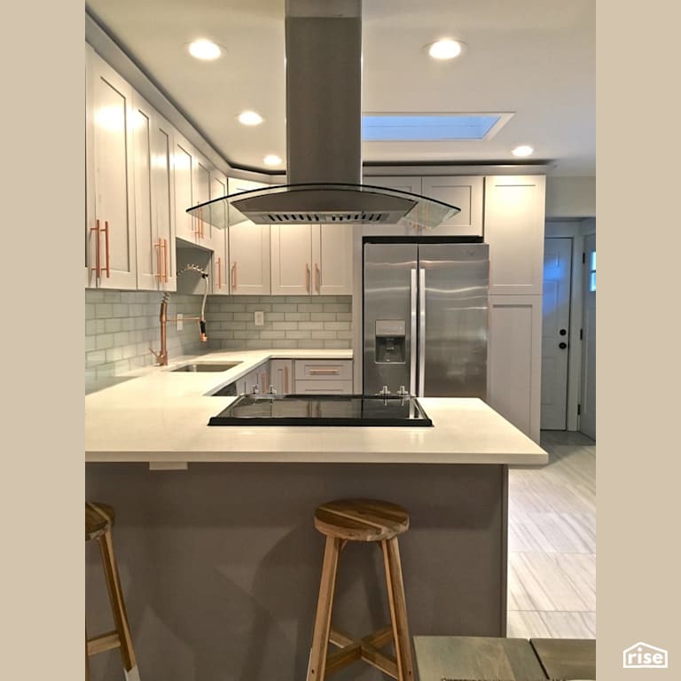 Updated kitchen with natural skylight with Low-Flow Kitchen Faucet by Revolve Design Build