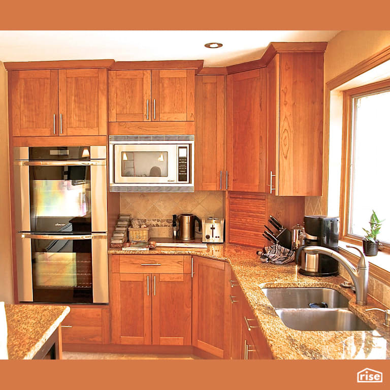 Wood grain kitchen with double wall oven with Low-Flow Kitchen Faucet by Revolve Design Build