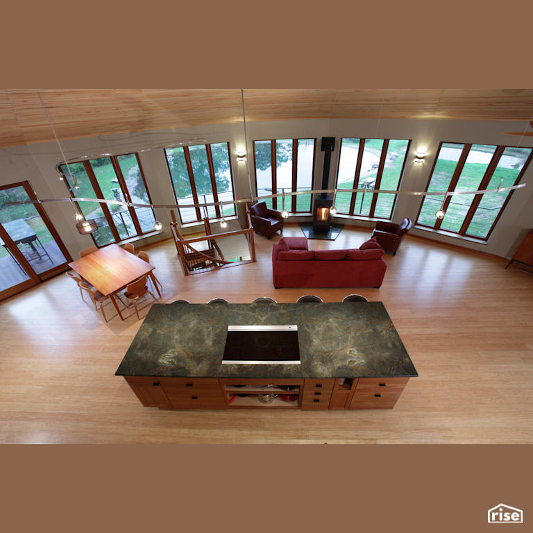 Open concept kitchen with wood stove with Accent Outdoor Lighting by Deltec Homes