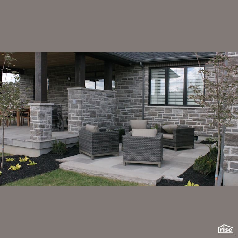 Stone patio with mulched garden beds with Stone Siding by Masonal Stone Inc