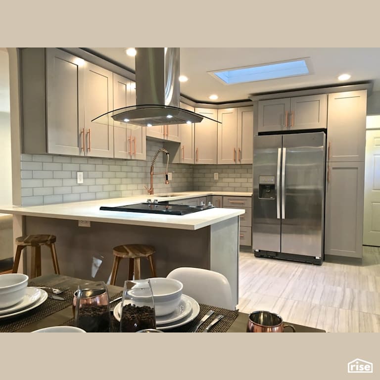 Open concept kitchen with skylight with Low-Flow Kitchen Faucet by Revolve Design Build