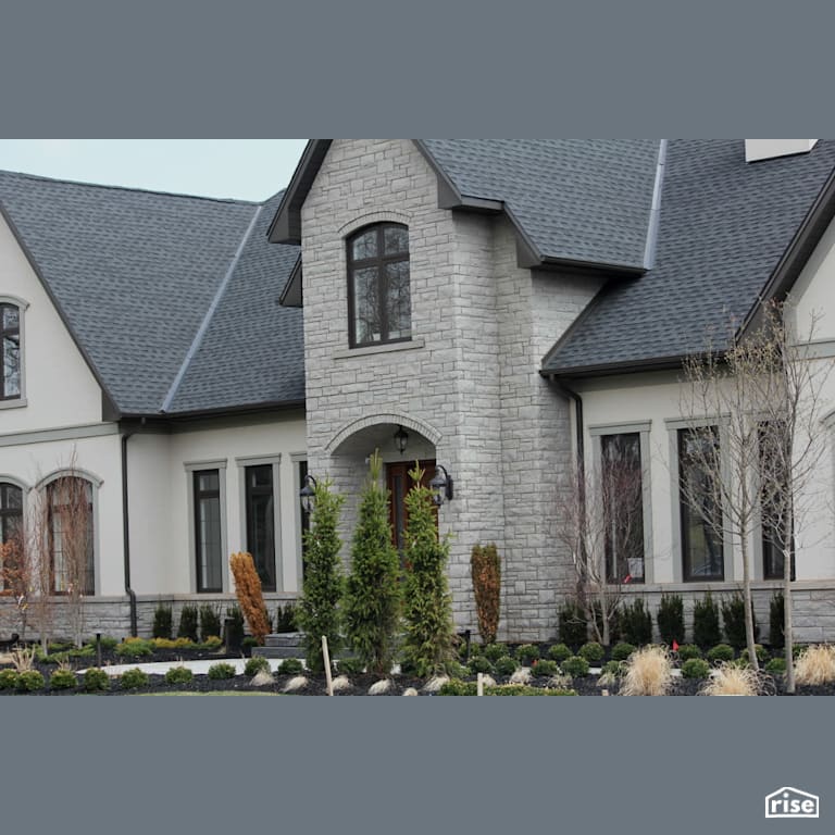 Landscaped home with stone siding with Wood Mulch by Masonal Stone Inc
