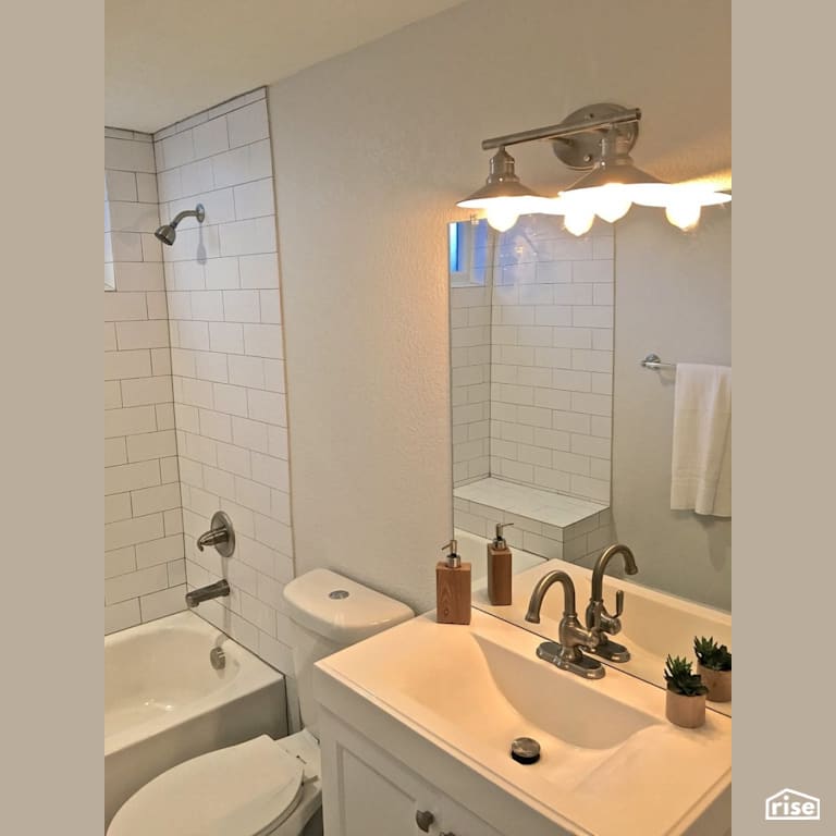 Updated bath with dual flush toilet and low-flow showerhead with Low-Flow Showerhead by Revolve Design Build