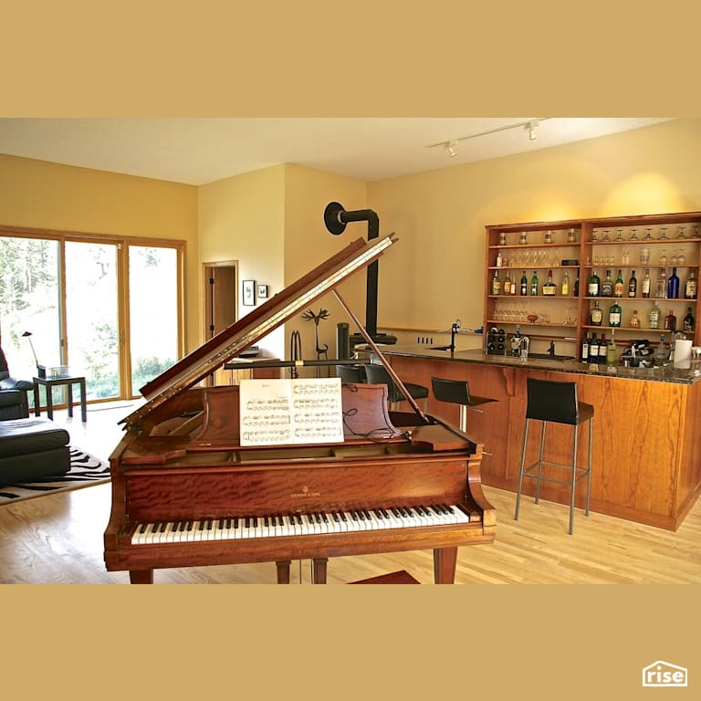 Home bar with piano with Wood Stove by Revolve Design Build