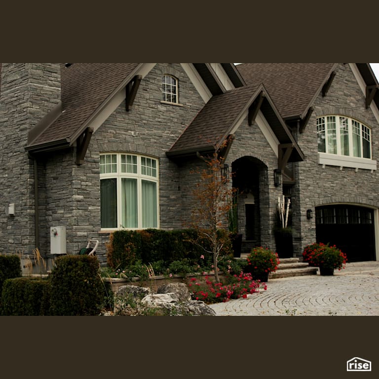 Front exterior of stone house with Accent Outdoor Lighting by Masonal Stone Inc