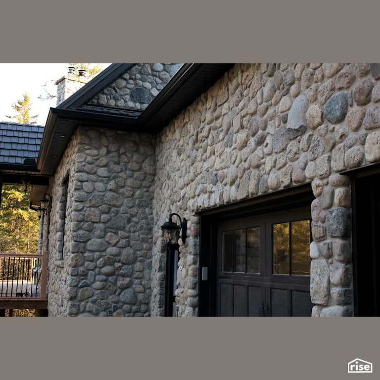 Home with rubble stone exterior with Accent Outdoor Lighting by Masonal Stone Inc