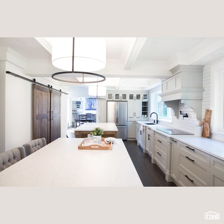 Open concept kitchen with sliding barn doors with Low-Flow Kitchen Faucet by Reimagine Designs