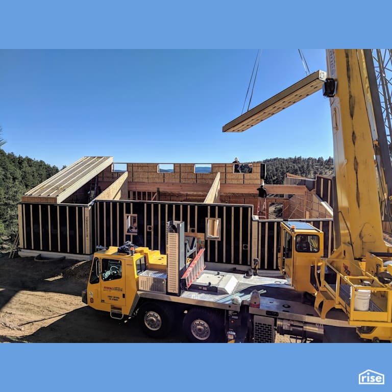 Panelized prefab Passive House with crane installing roof with Prefabricated Panelized Home by Phoenix Haus LLC