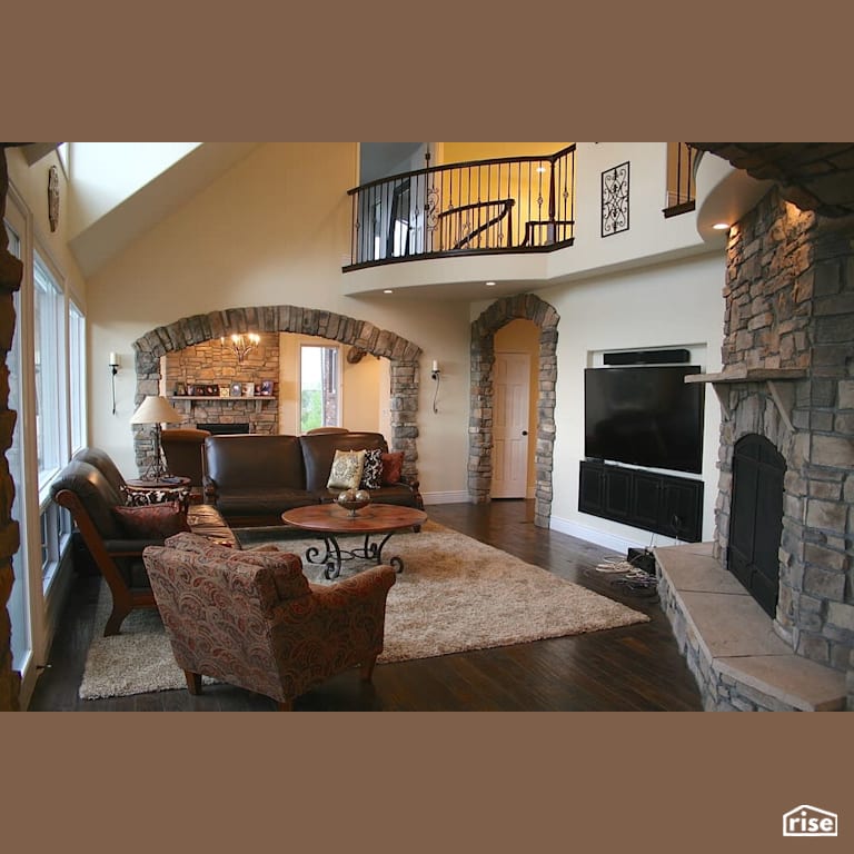 Large family room with wood burning fireplace with Engineered Hardwood by Revolve Design Build