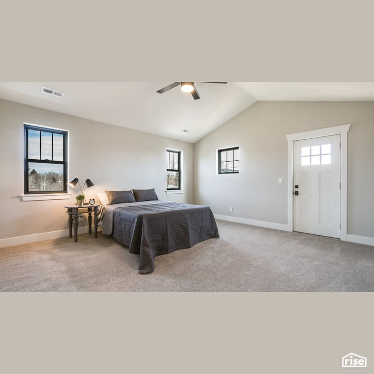 Bedroom with dark grey bedding with Carpeting by Revolve Design Build