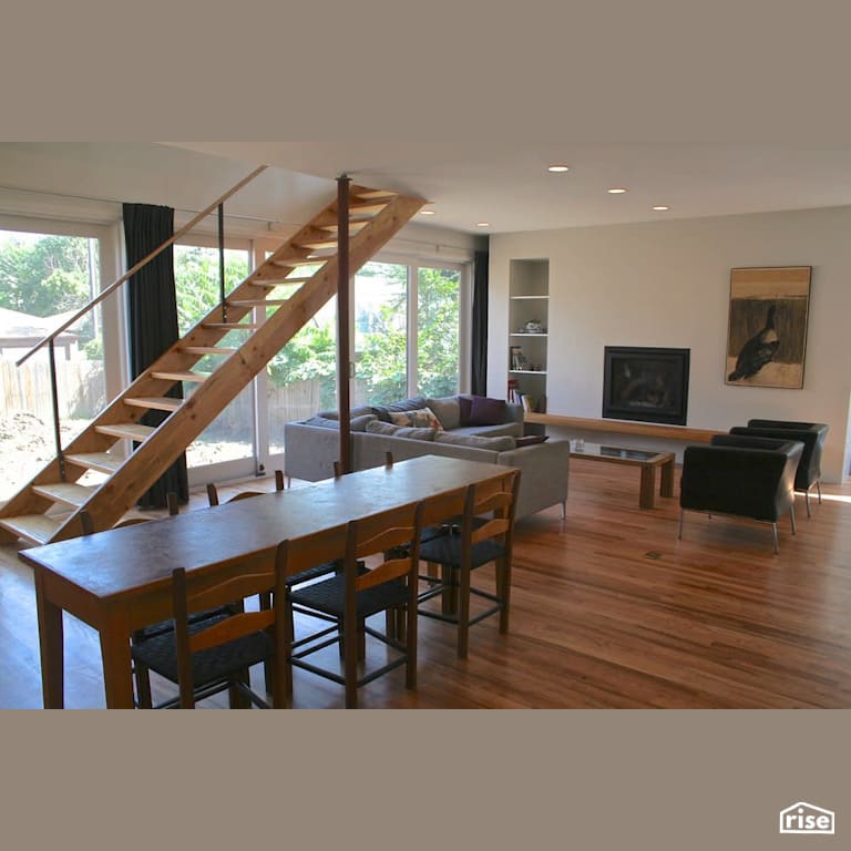 Open concept family room with staircase with Gas Fireplace by Revolve Design Build