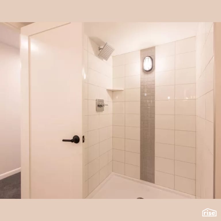 Bathroom with Low-Flow Showerhead by Constructive Builders