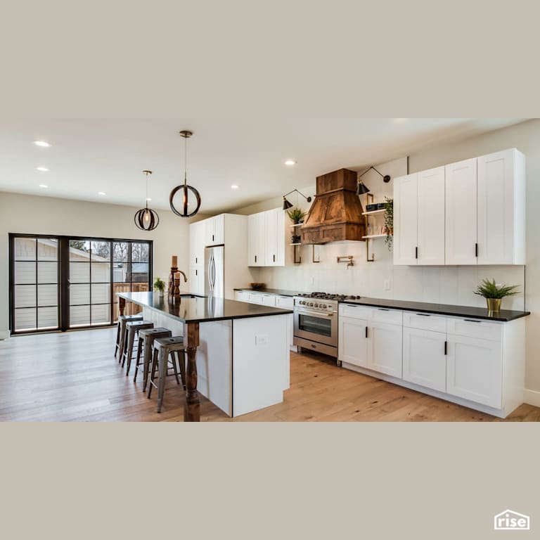 Open concept kitchen with wood feature range hood with FSC Certified Wood Cabinet by Revolve Design Build