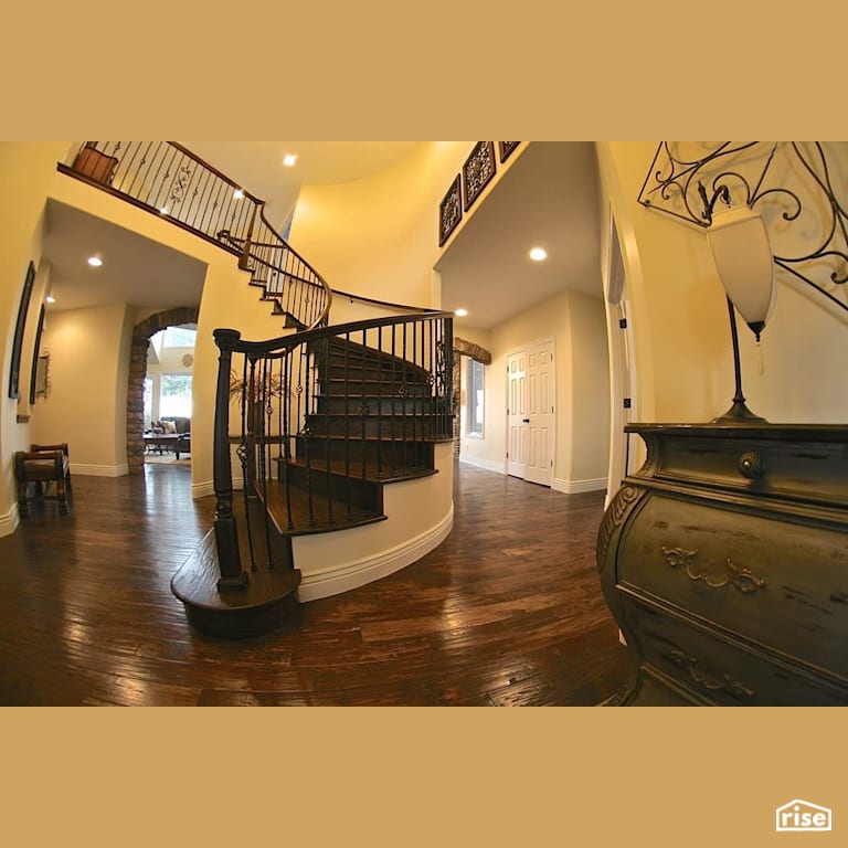 Large spiral staircase at entryway with Integrated LED by Revolve Design Build