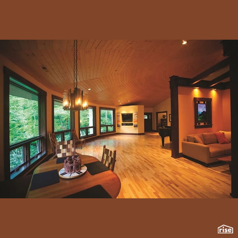 Open concept living area with dining table and piano with Engineered Hardwood by Deltec Homes