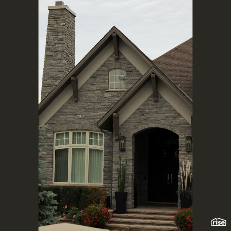 Stone home with arched entryway with Stone Siding by Masonal Stone Inc
