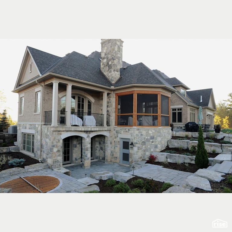 Stone house with stone patio with Accent Outdoor Lighting by Masonal Stone Inc