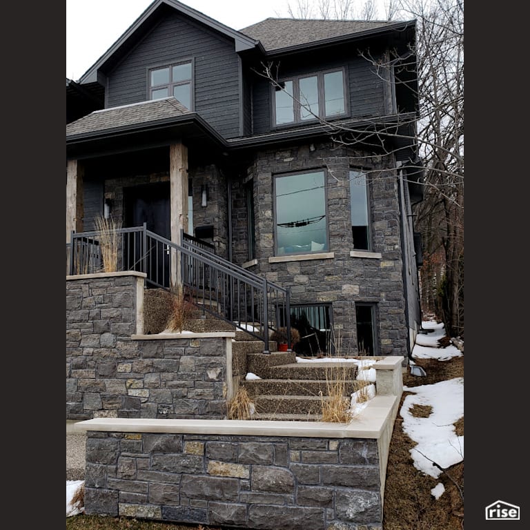 Two story stone sided home with Accent Outdoor Lighting by Masonal Stone Inc