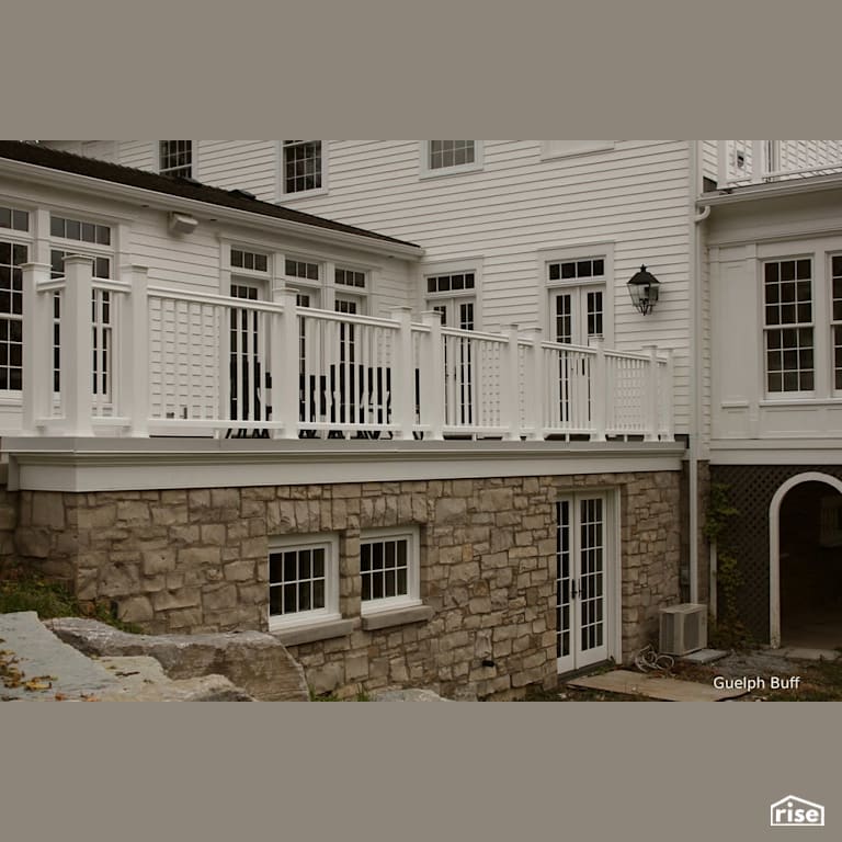 Stone siding below white deck with Stone Siding by Masonal Stone Inc