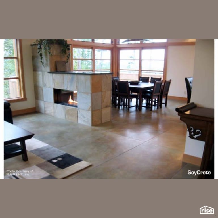 Open concept dining with SoyCrete floors around fireplace with Concrete Stain by Eco Safety Products