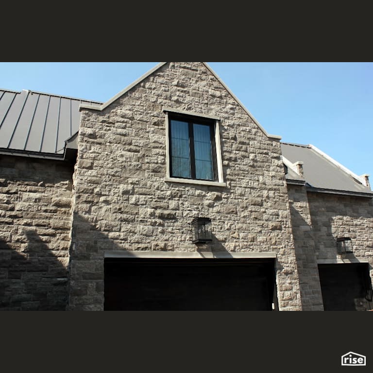 House with Stone Siding with Accent Outdoor Lighting by Masonal Stone Inc