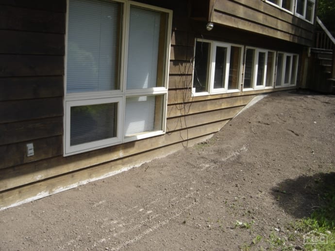 Grading is above wood siding causing damage