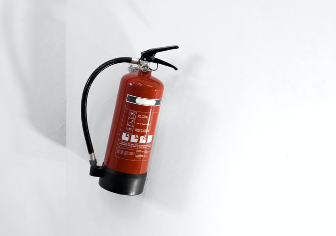 red fire extinguisher hanging on wall