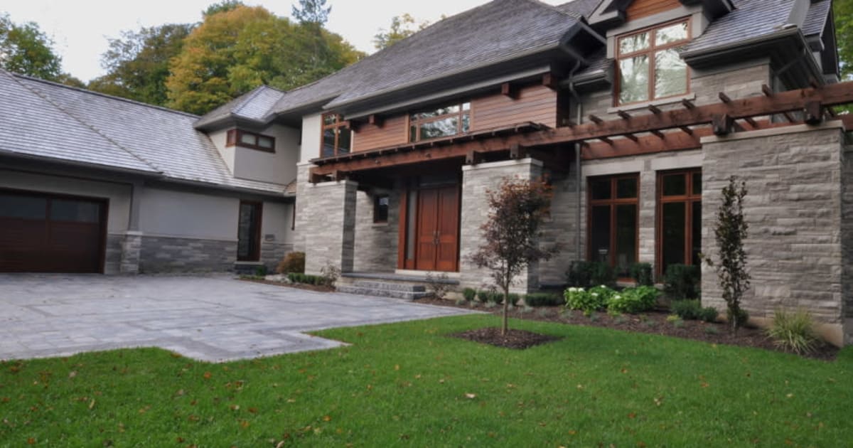 Rise | Stone house with stone driveway with Wood Mulch by Masonal Stone Inc